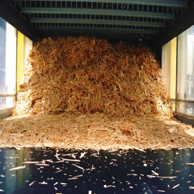 A large pile of shredded wood particles inside a particle board plant