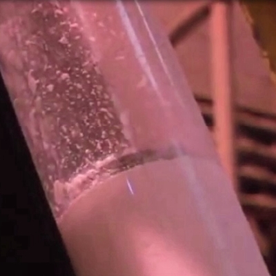 A large clear tube carrying formaldehyde resin into wood particles