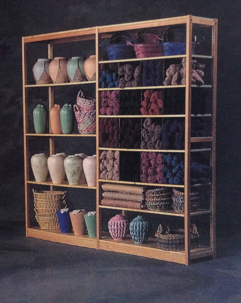 Pine shelving display with vases, baskets, and yarn skeins in craft store