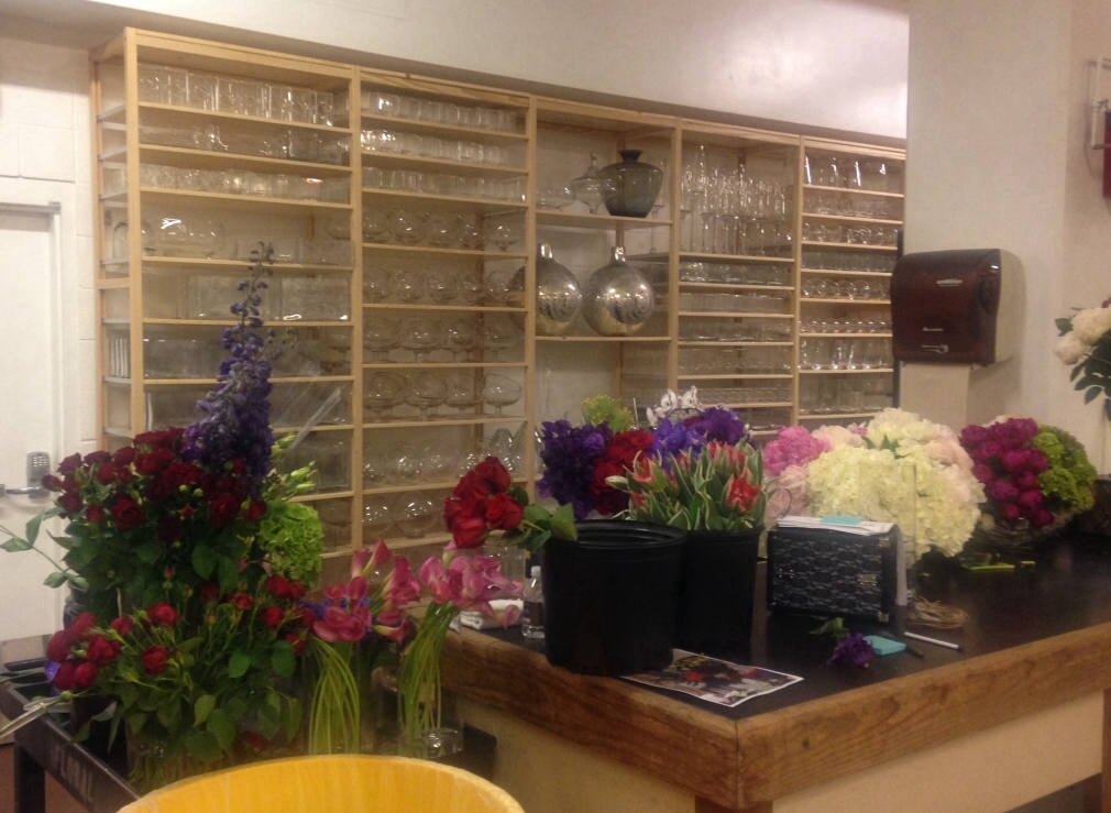 Florist workspace solid wood shelving with vases and glassware